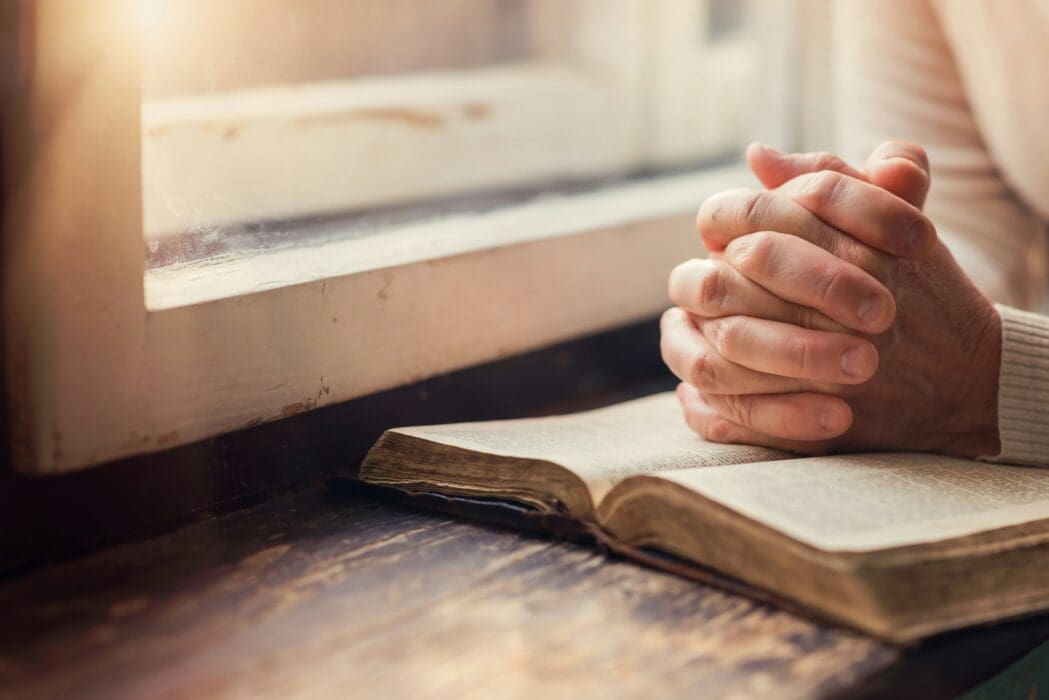 Hands on Top of Bible