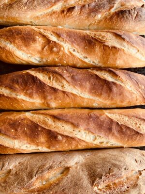 A row of golden baguettes fresh from the oven, echoing the farmer's twenty loaves of firstfruits