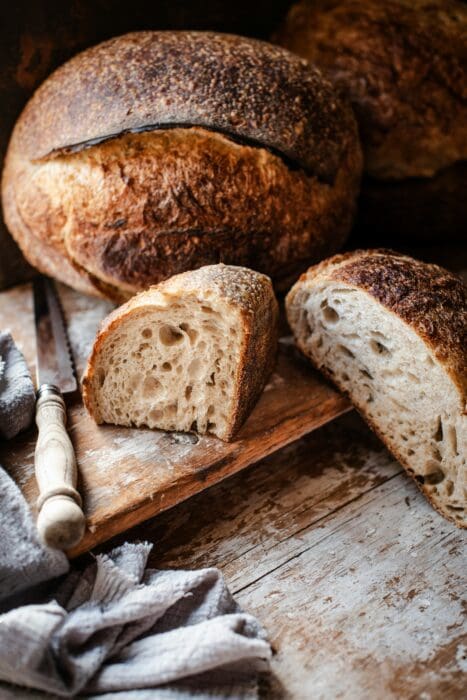 Fresh-baked loaves cut open on a board, showing what little God multiplies into plenty