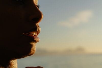 A close profile of lips speaking in golden sunset light, a picture of words God fully hears