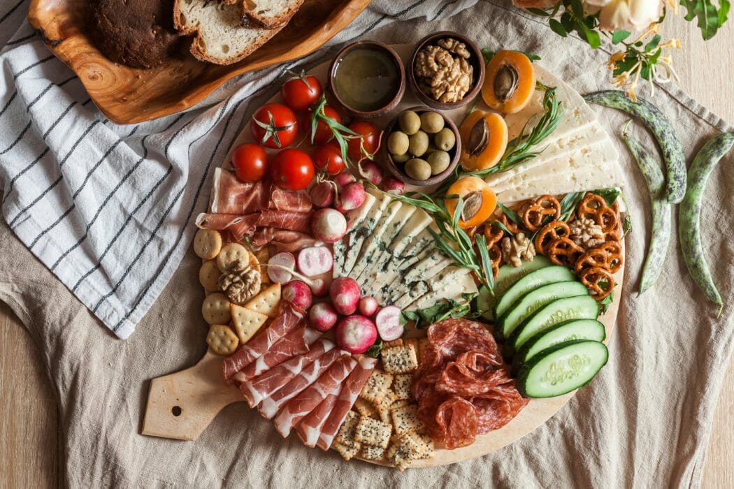A generous spread of meats, cheeses, and fruit on a board, echoing the feast prepared for enemies