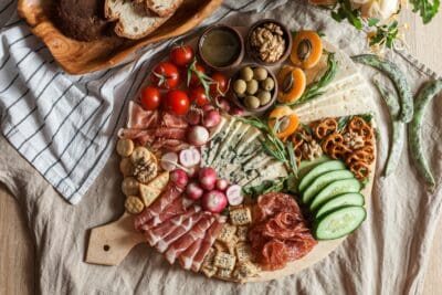 A generous spread of meats, cheeses, and fruit on a board, echoing the feast prepared for enemies