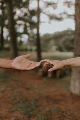 Two hands reach toward each other, almost touching, a picture of doubt daring to investigate