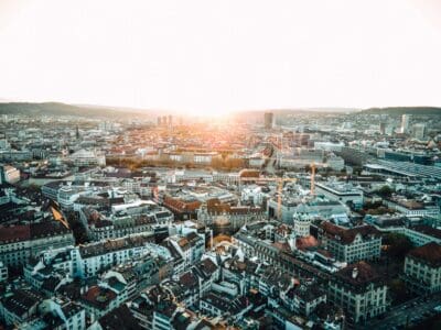 Aerial view of a dense city skyline glowing at sunrise, evoking the broken world Ecclesiastes questions.