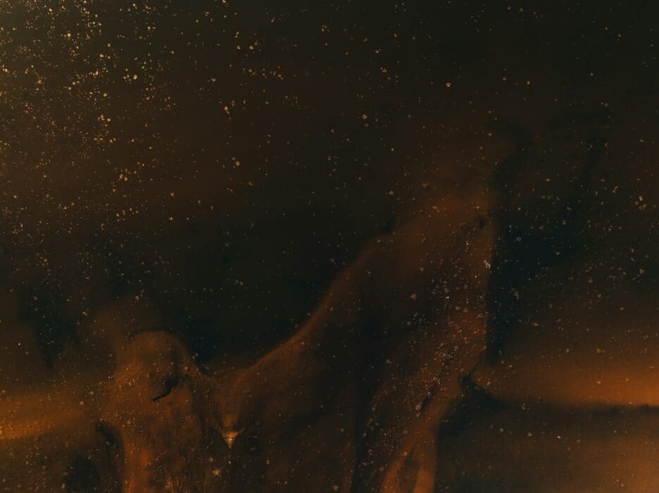A hazy, golden silhouette emerging from darkness, picturing new life born of the Spirit.