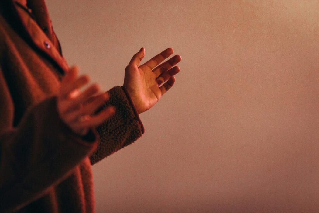 Open hands reaching out in warm light, the posture of the first people who called on the Lord.