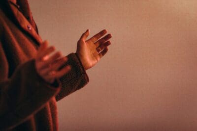 Open hands reaching out in warm light, the posture of the first people who called on the Lord.