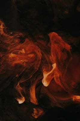 Swirling orange smoke curling through darkness, picturing the imagination indulging hidden cravings.